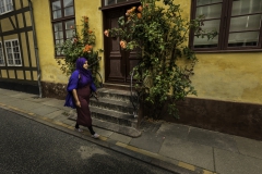 Foto: Steffen Jensen | Yasmins blå og lilla tøj gør sig fint med Rudkøbings gamle huses gule puds.